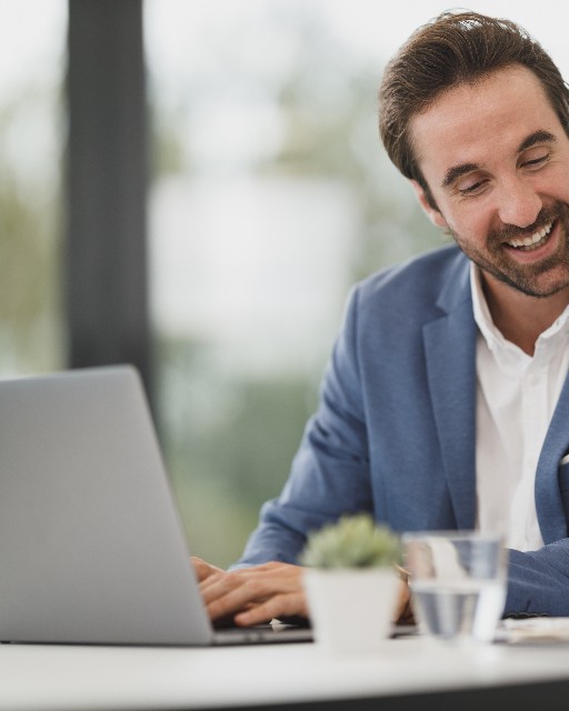 Entrepreneur souriant devant son ordinateur portable